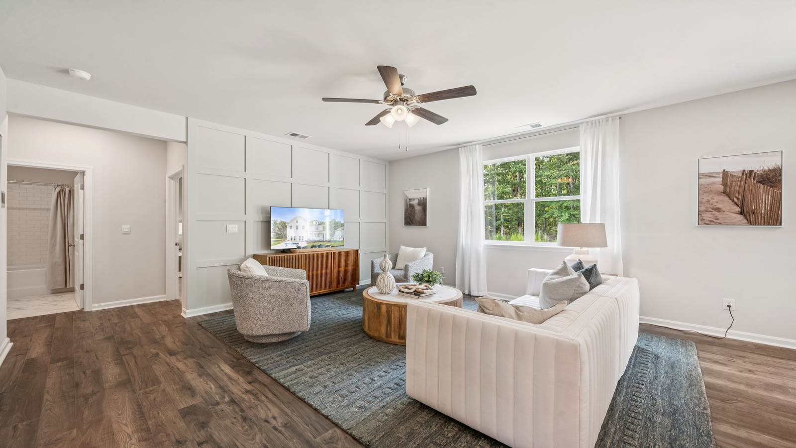 Living room in this new construction home features natural light, with fresh open concept flow to the kitchen