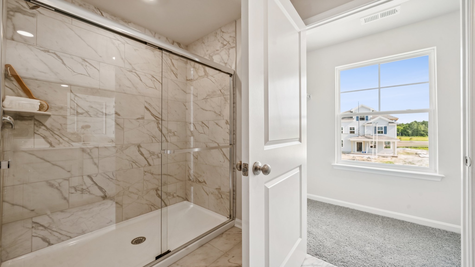 Primary ensuite bathroom in D.R. Horton's new home featuring an expansive vanity with dual sinks, shower, tub, walk-in closet