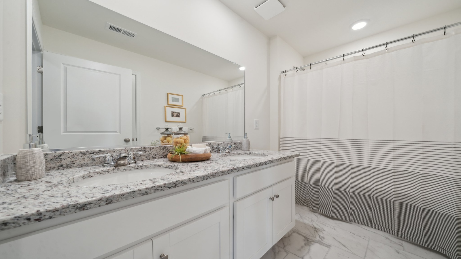 Guest, family bathroom with sink and vanity, large mirror, decorative hand towel at Green Spring Estates by D.R. Horton