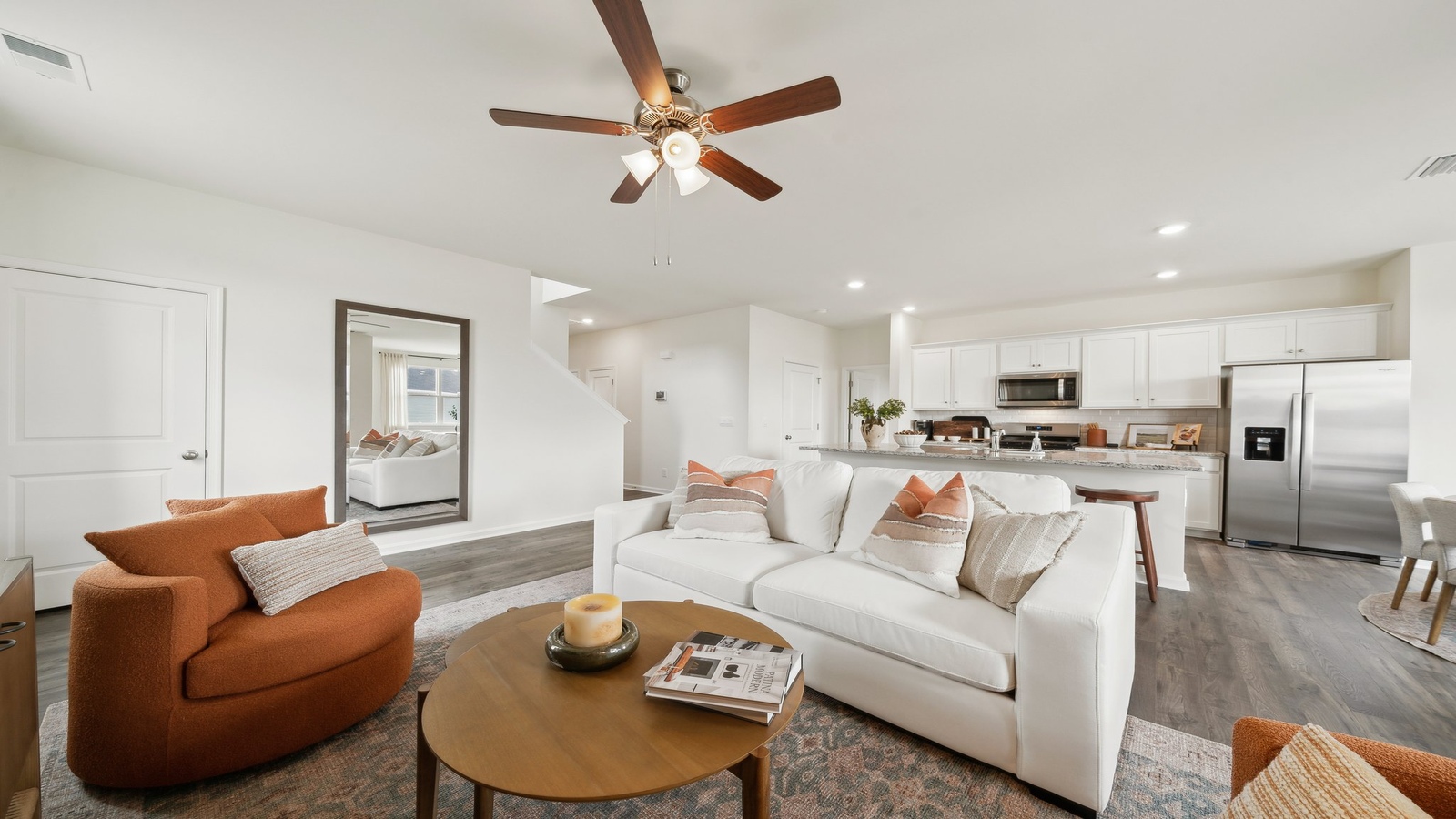 Spacious living room looking toward modern kitchen with island, dining, new appliances at Green Spring Estates