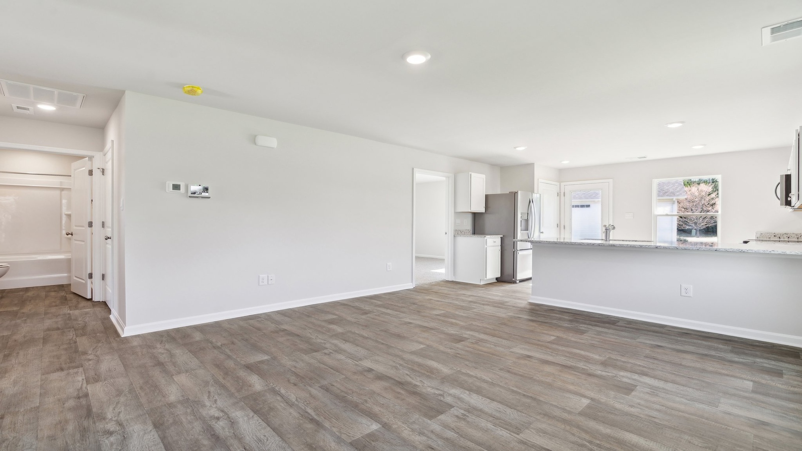 Kitchen, dining, family room blend together with ease of access to backyard view, upstairs access in D.R. Horton new home