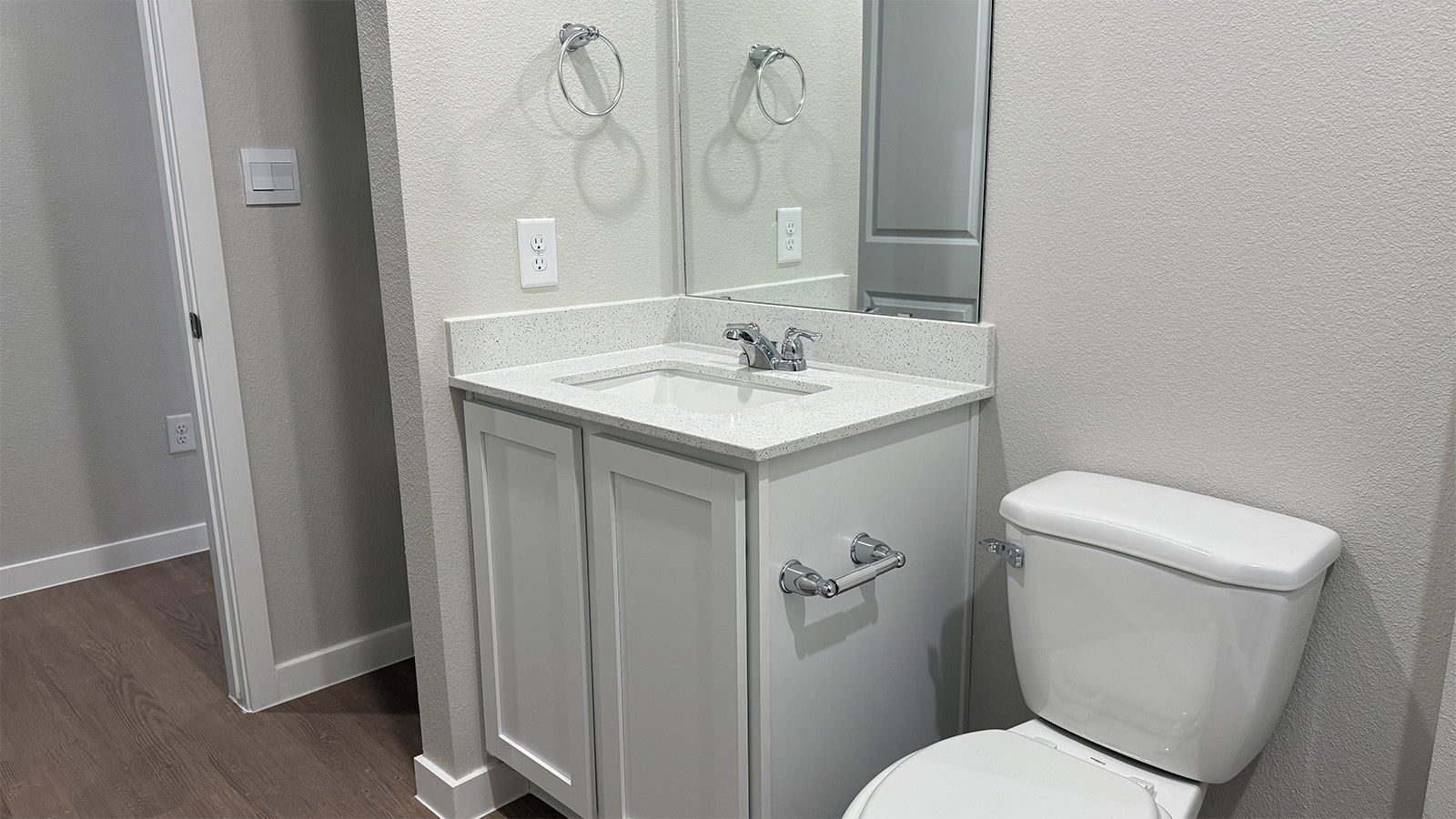 Half bath with door opening to hallway, pedestal sink, mirror visible with shiny faucet in Shiloh Springs