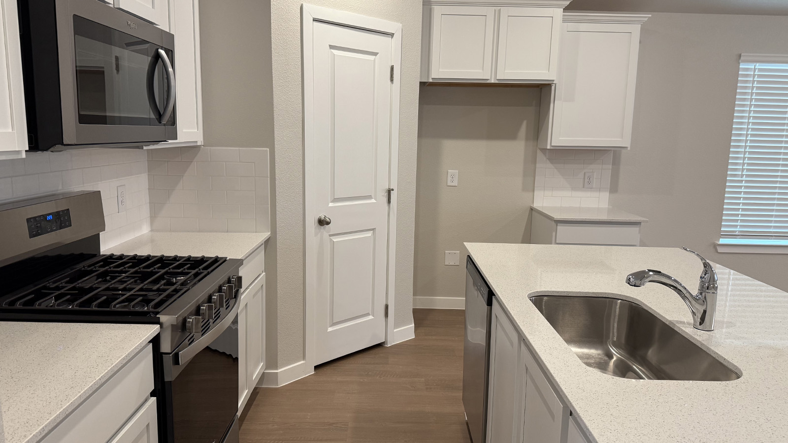 New build home kitchen showcasing a center island with sink, pantry, new appliance suite included, multiple seating options