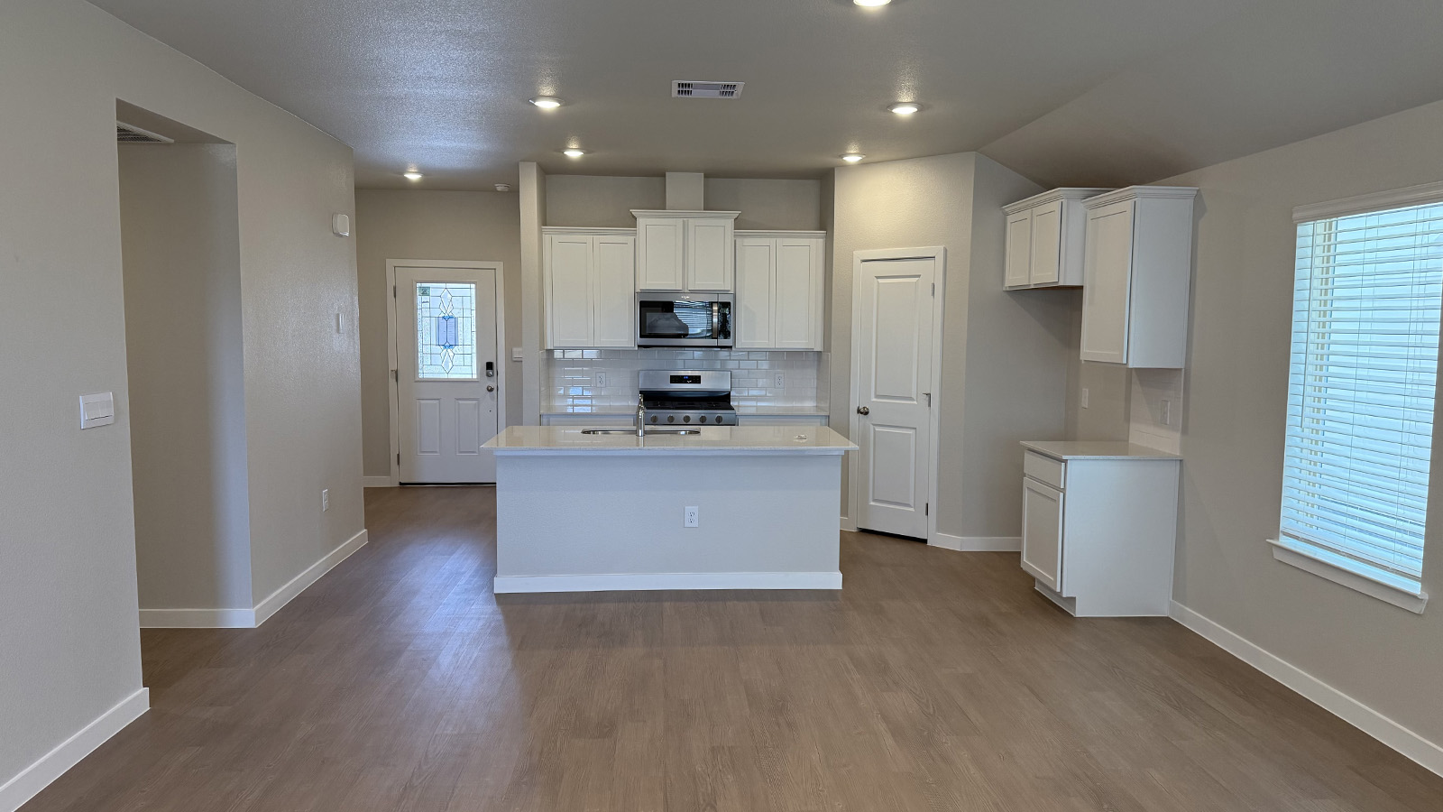 Shiloh Springs view from living room to modern designed kitchen with pantry, new appliance suite included, stair entry