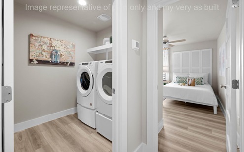 laundry room with side by side machines and storage above