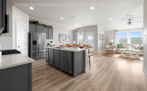 kitchen looking into living room and large windows to backyard