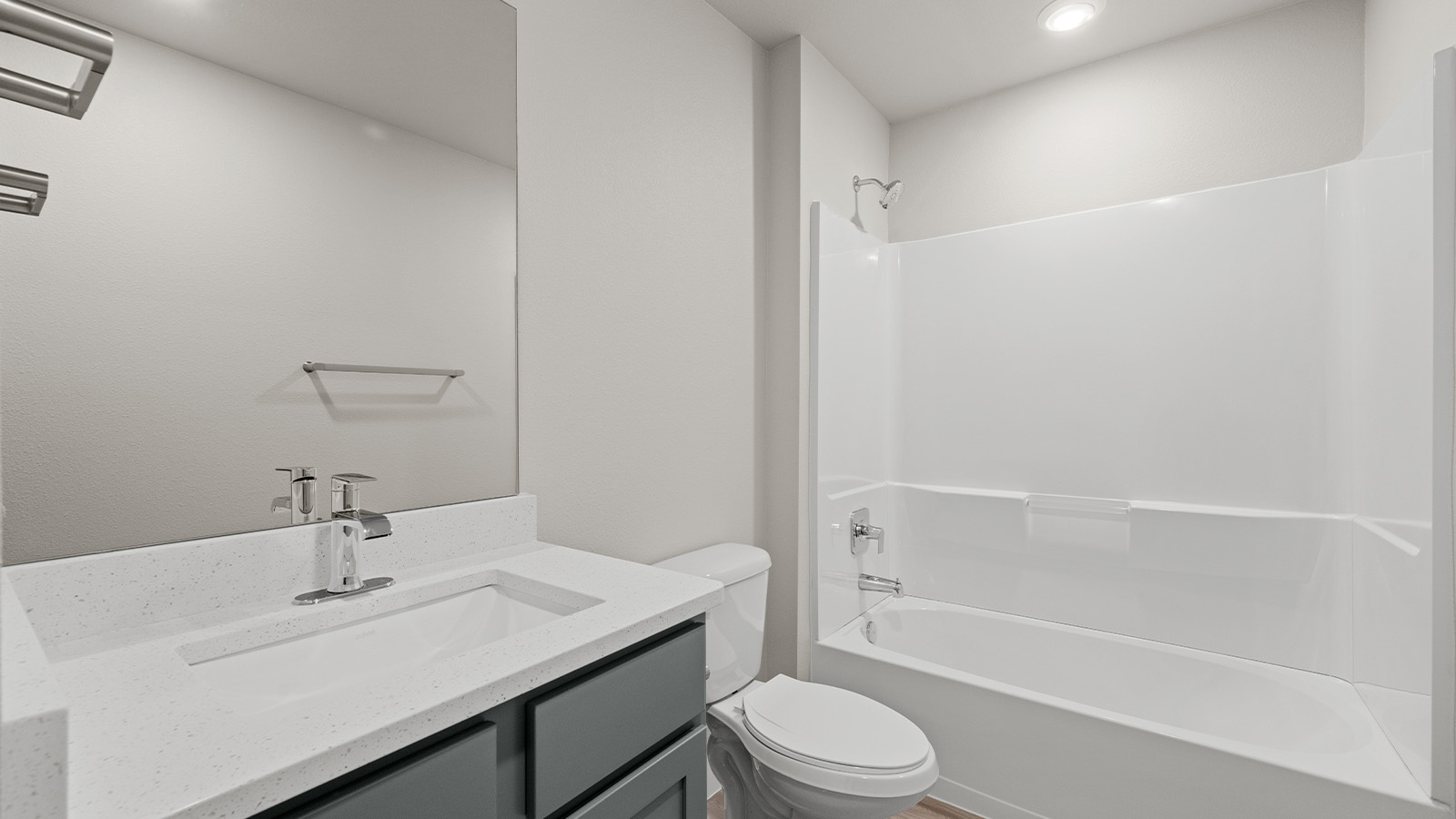 second bathroom with grey cabinets and blanco quartz counters