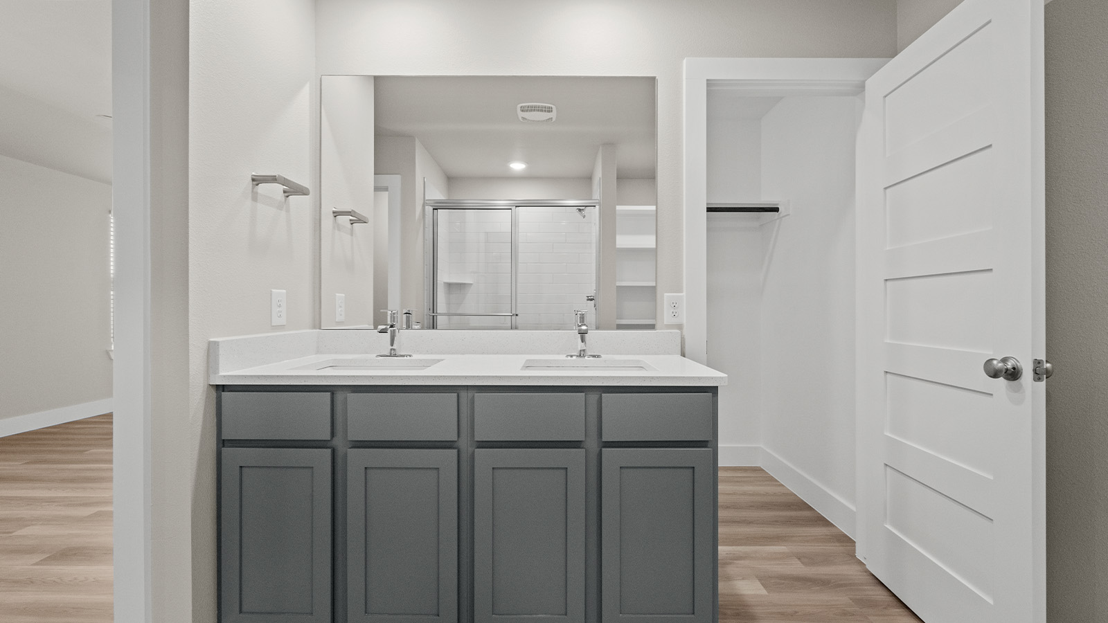 Primary bath with grey cabinets, blanco quartz counters and dual vanities