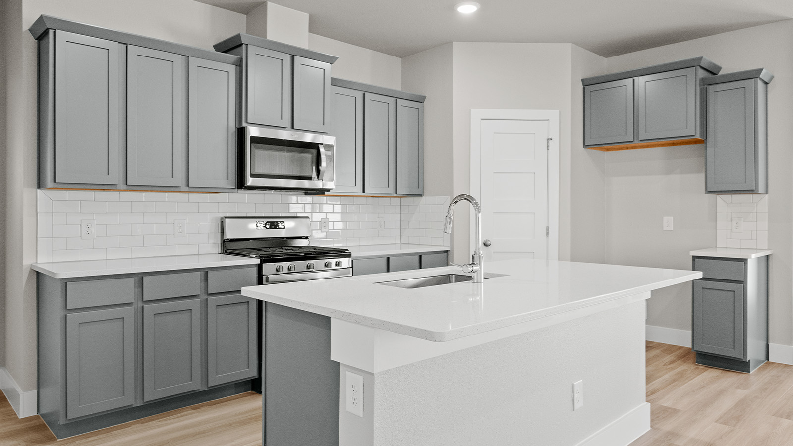 Kitchen with gray shaker cabinets and Blanco Quartz counters