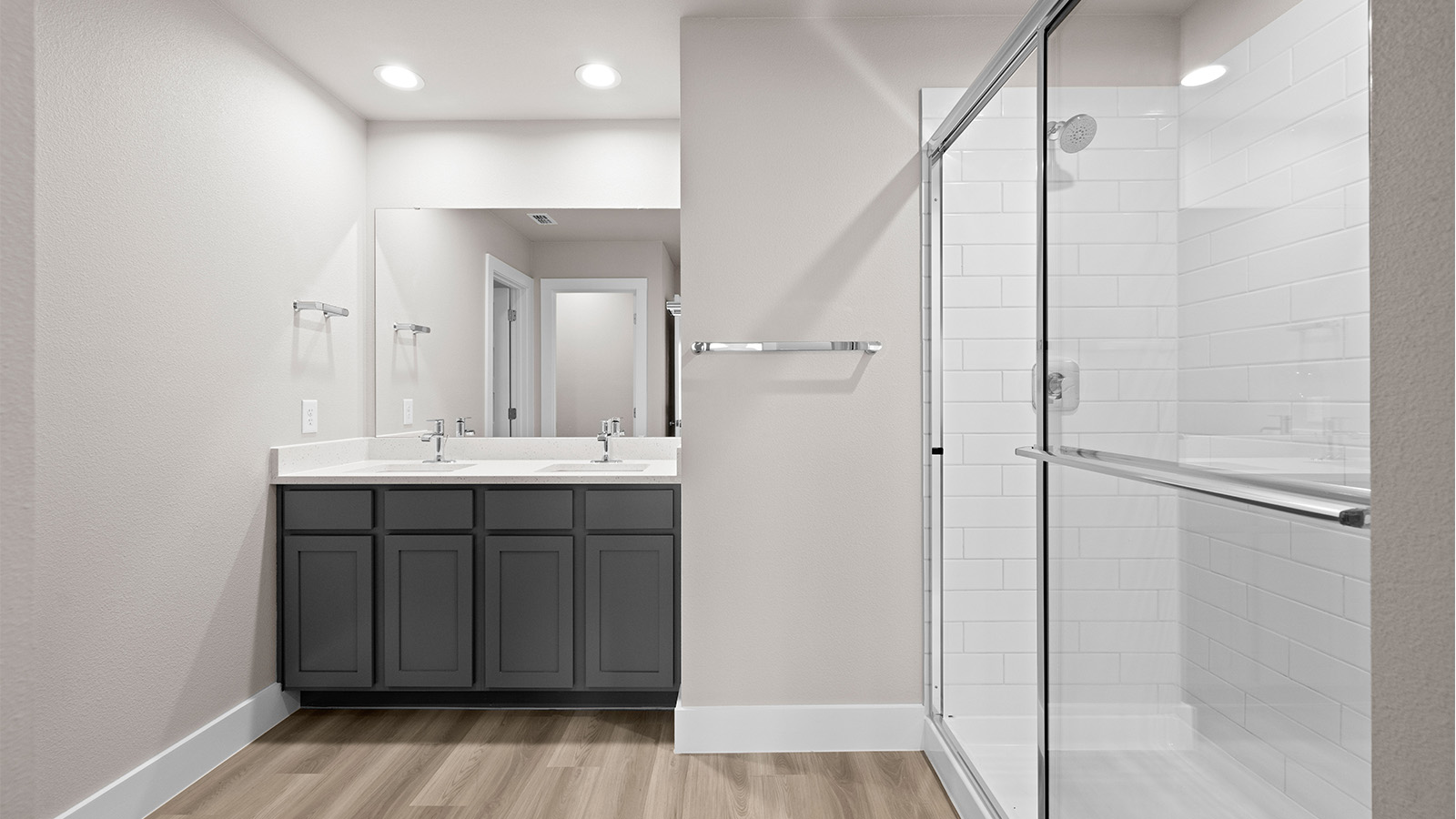 primary bathroom with dual vanities quartz counters and under sink storage