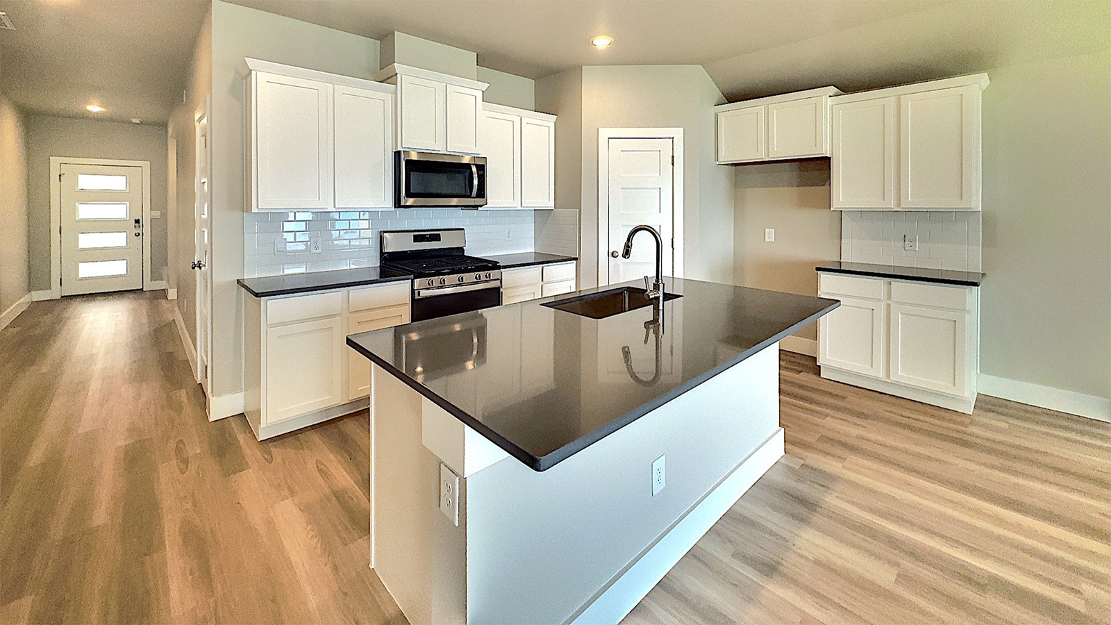 Island kitchen with Rockport Gray Quartz counters and while maple shakers cabinets