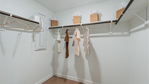 Spacious walk in closet with built in shelving in the primary bathroom.