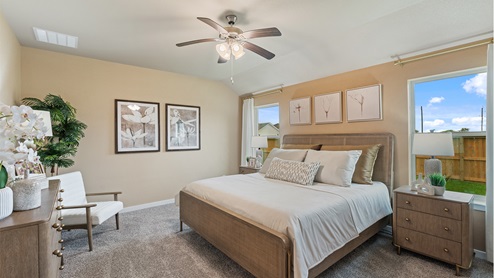 Primary bedroom with carpeted floors, two large windows, and trey ceilings.