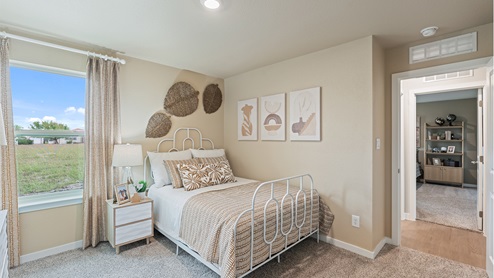 Bedroom one with carpeted floors and large single window for natural light.