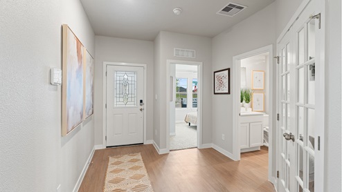 Front entryway and foyer with light hardwood floors with doors to the right.