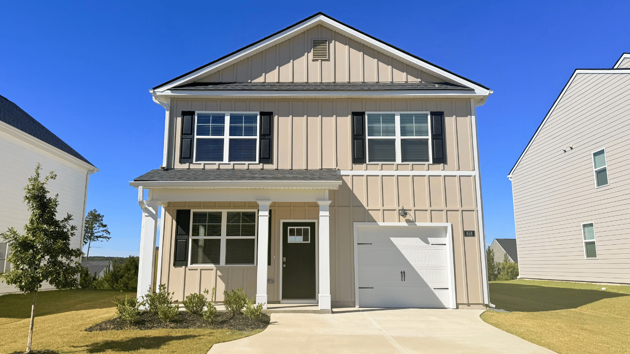 Two story tan home with one-car garage.