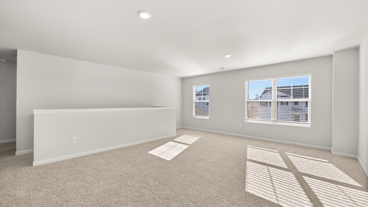 Huge loft upstairs at top of staircase with half wall.