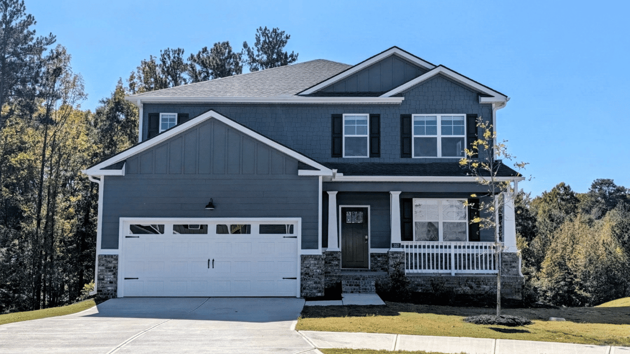 Two story blue home with covered porch and two car garage