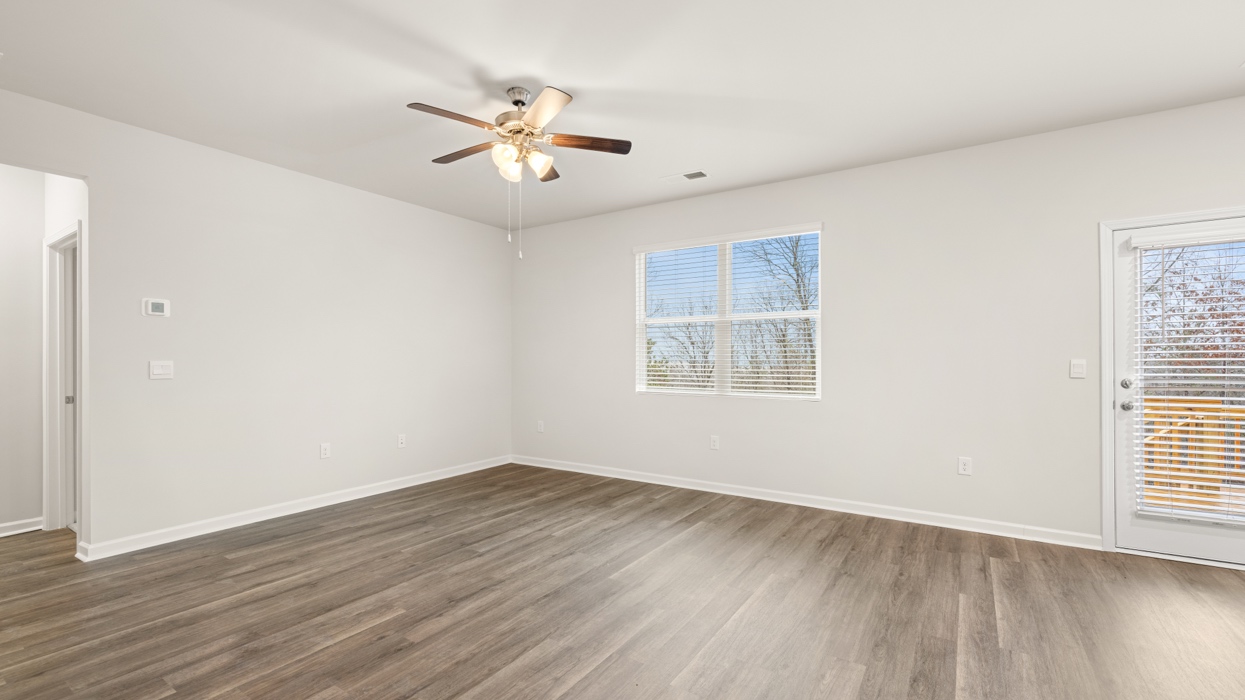 angled living room with natural light and ceiling fan