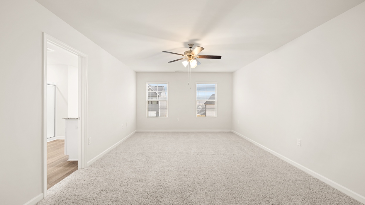 primary bedroom with natural light and ceiling fan