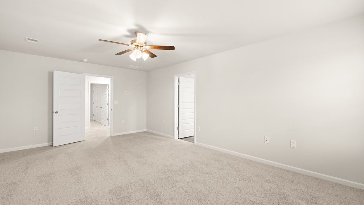 angled primary bedroom with ceiling fan