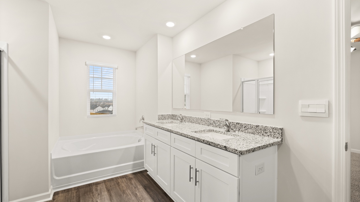 primary bathroom with dual sinks and natural light