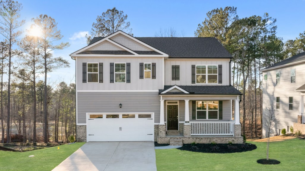 Two story grey home with covered front porch and two car garage