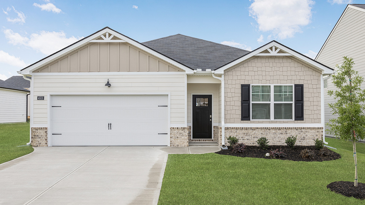 Single story ranch home in cream with two-car garage
