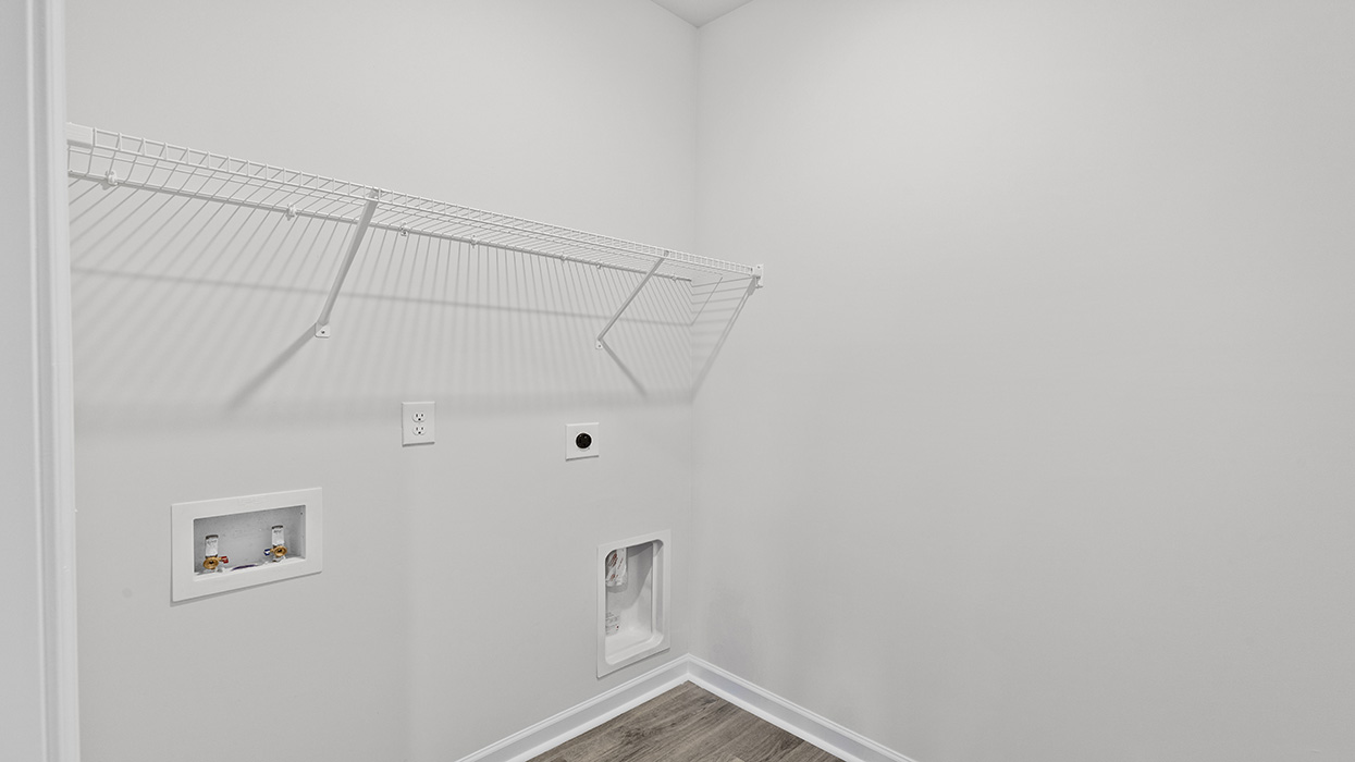 Laundry room with washer and dryer connections and shelving above