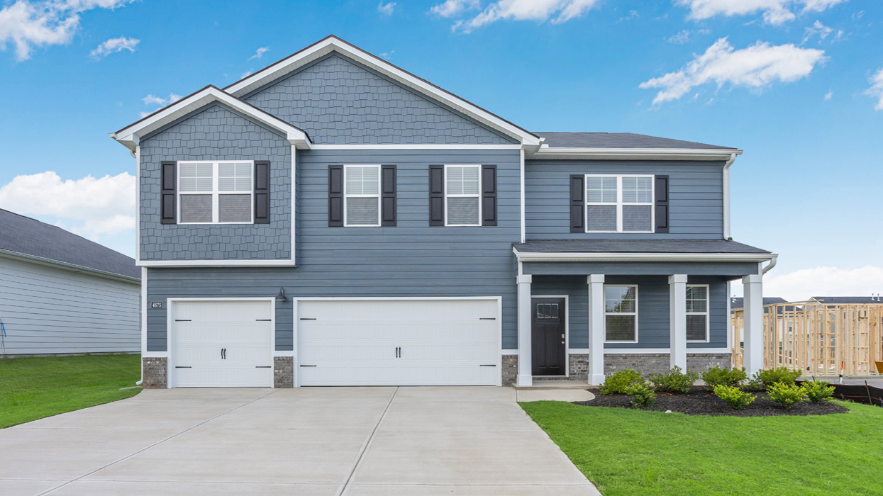 Two story blue home with covered porch and three car garage