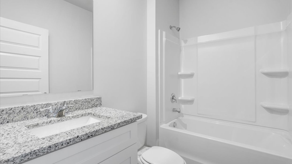 Guest bath with single vanity, commode, and tub/shower combo