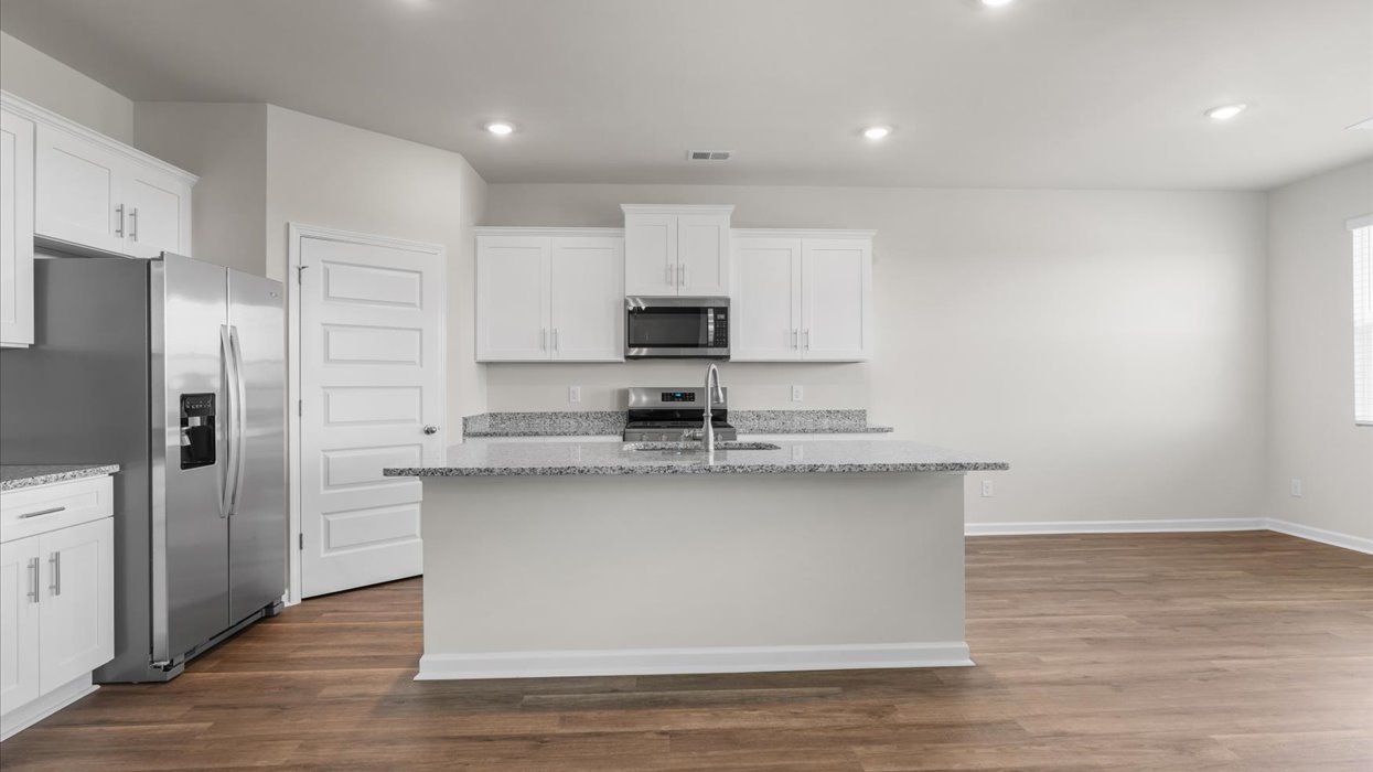 Bright and modern kitchen with white cabinetry, stainless steel appliances, and a large center island with bar seating