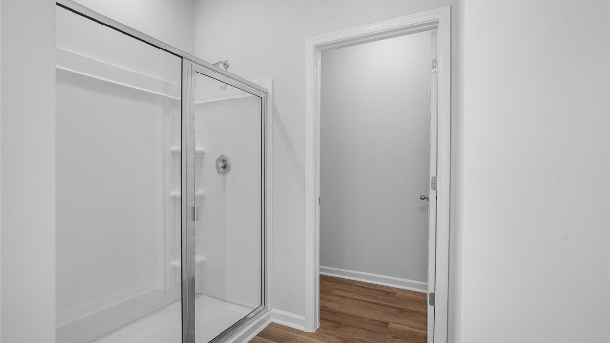 Primary bathroom with double vanity, soaking tub, and shower with glass door.