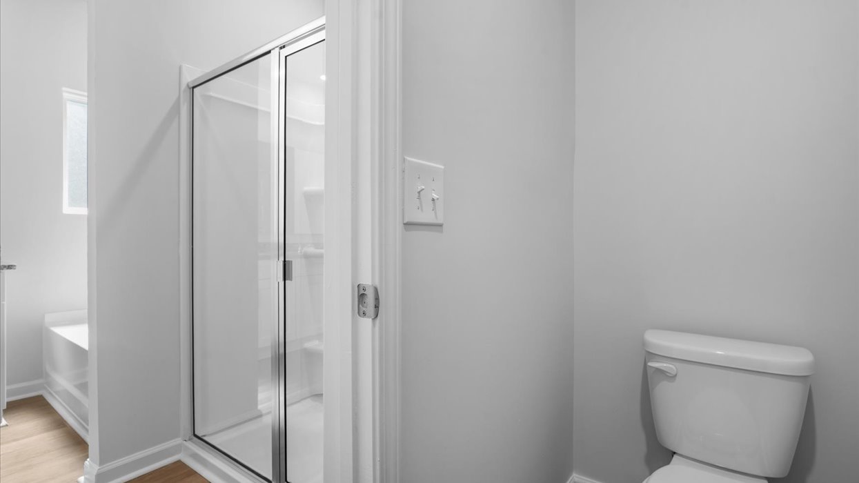 Primary bathroom with double vanity, soaking tub, and shower with glass door.