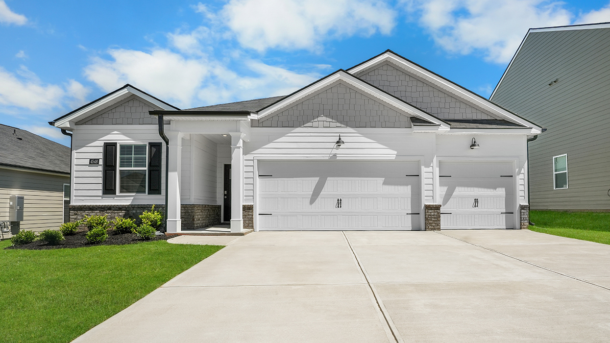 Single story ranch home in white with 3-car garage