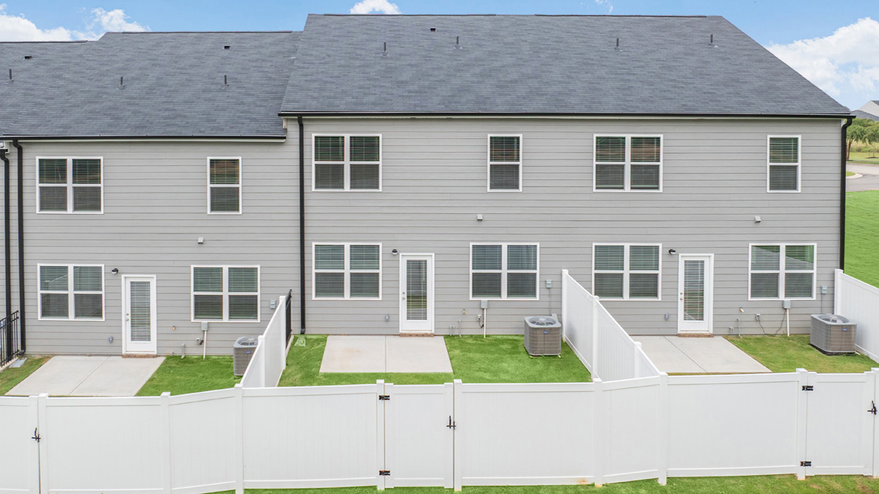 Rear of two story townhome with fenced in back yard