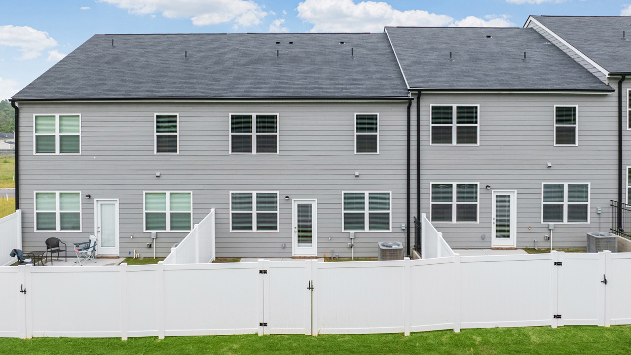 Rear of two story townhome with fenced back yard