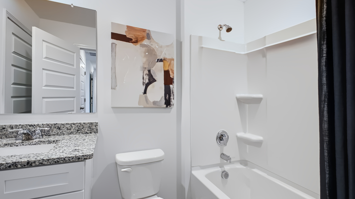 Guest bathroom with single vanity, commode, and combo tub/shower.