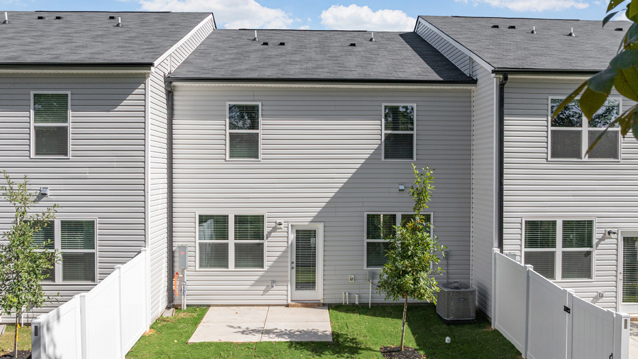 Rear of two story townhome with fenced in yard