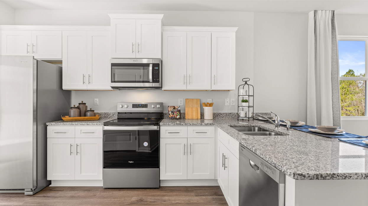 Modern kitchen with white cabinets, granite counters, and stainless appliances