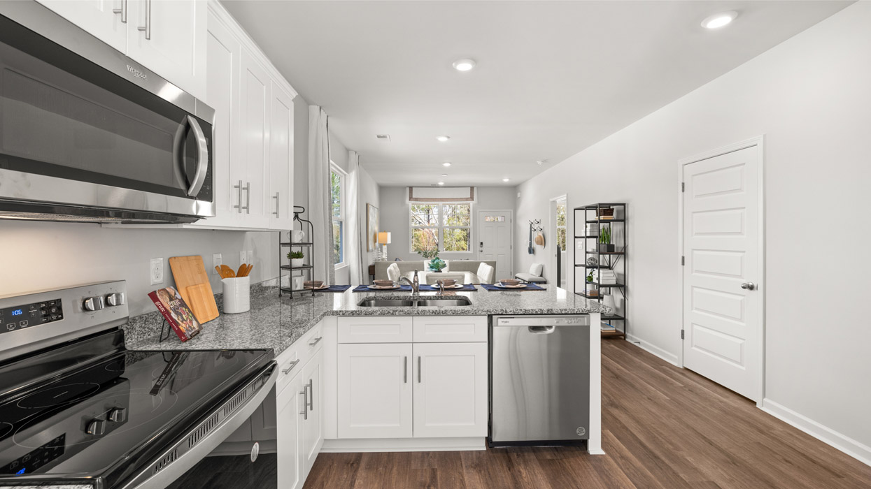 Modern kitchen with white cabinets, granite counters, and stainless appliances