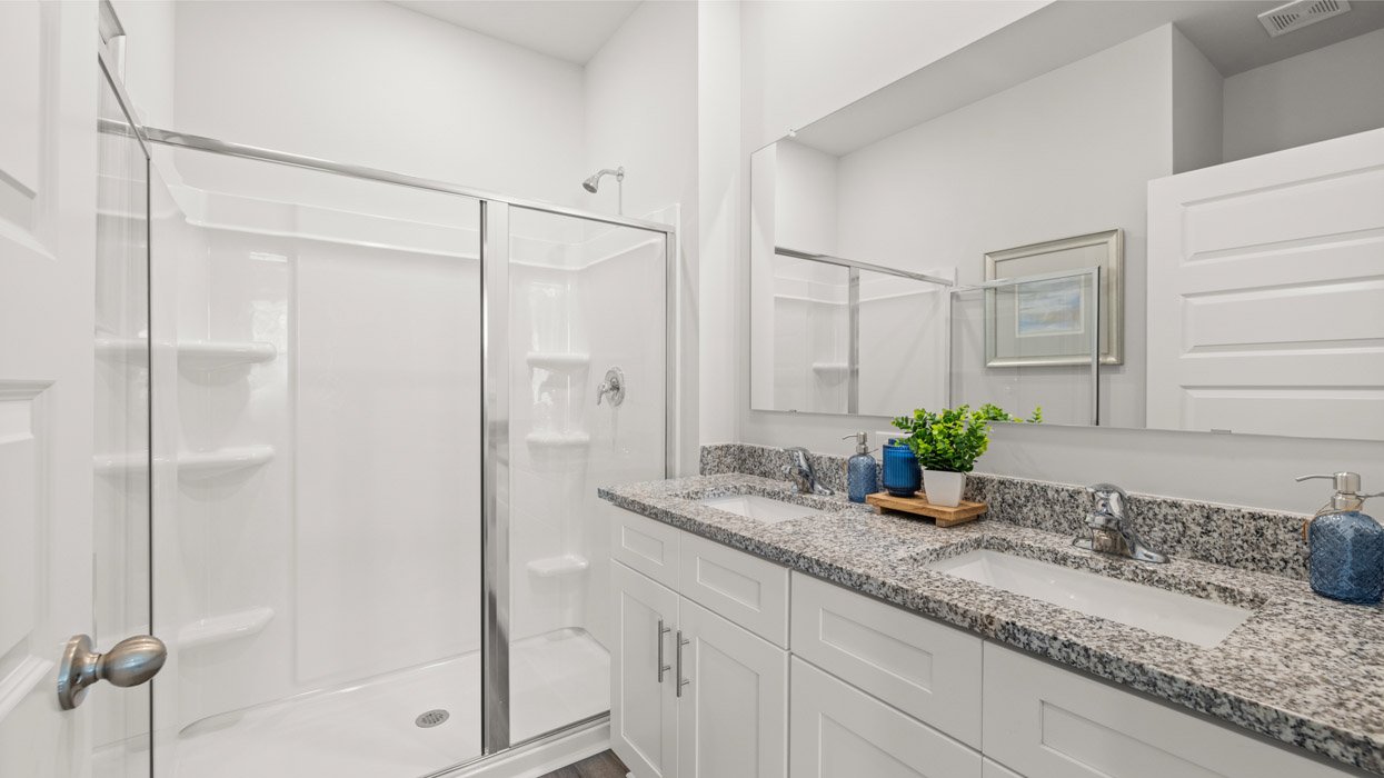 Primary bath with double vanity and shower with glass door