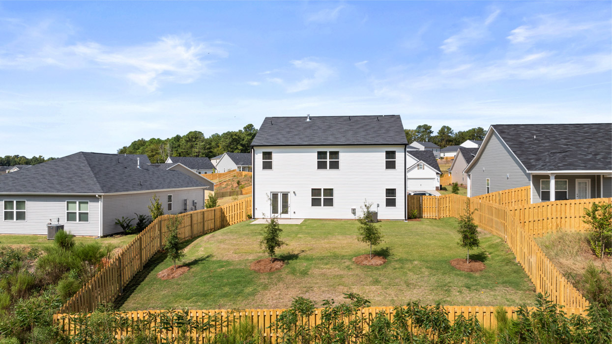 Rear of two story white home with backyard