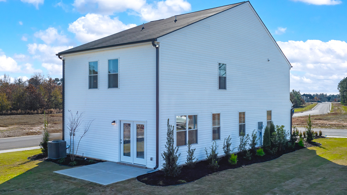 Rear of two story home with back patio