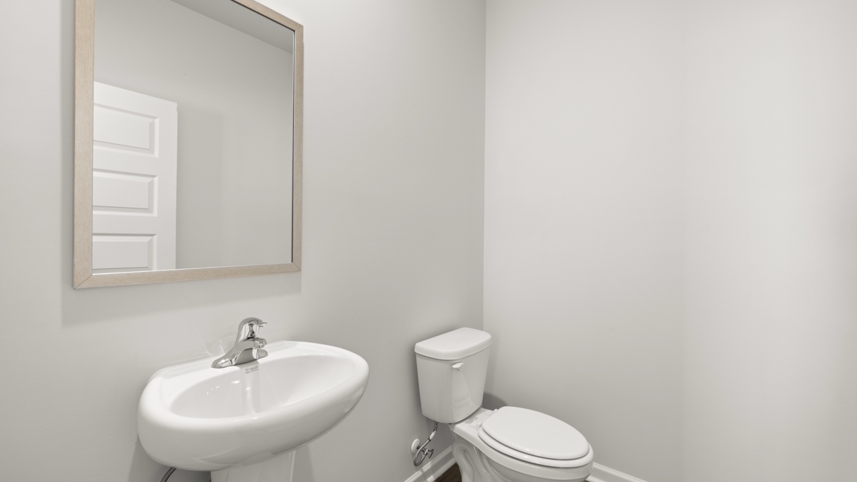 Half bath on main floor with pedestal sink off of dining