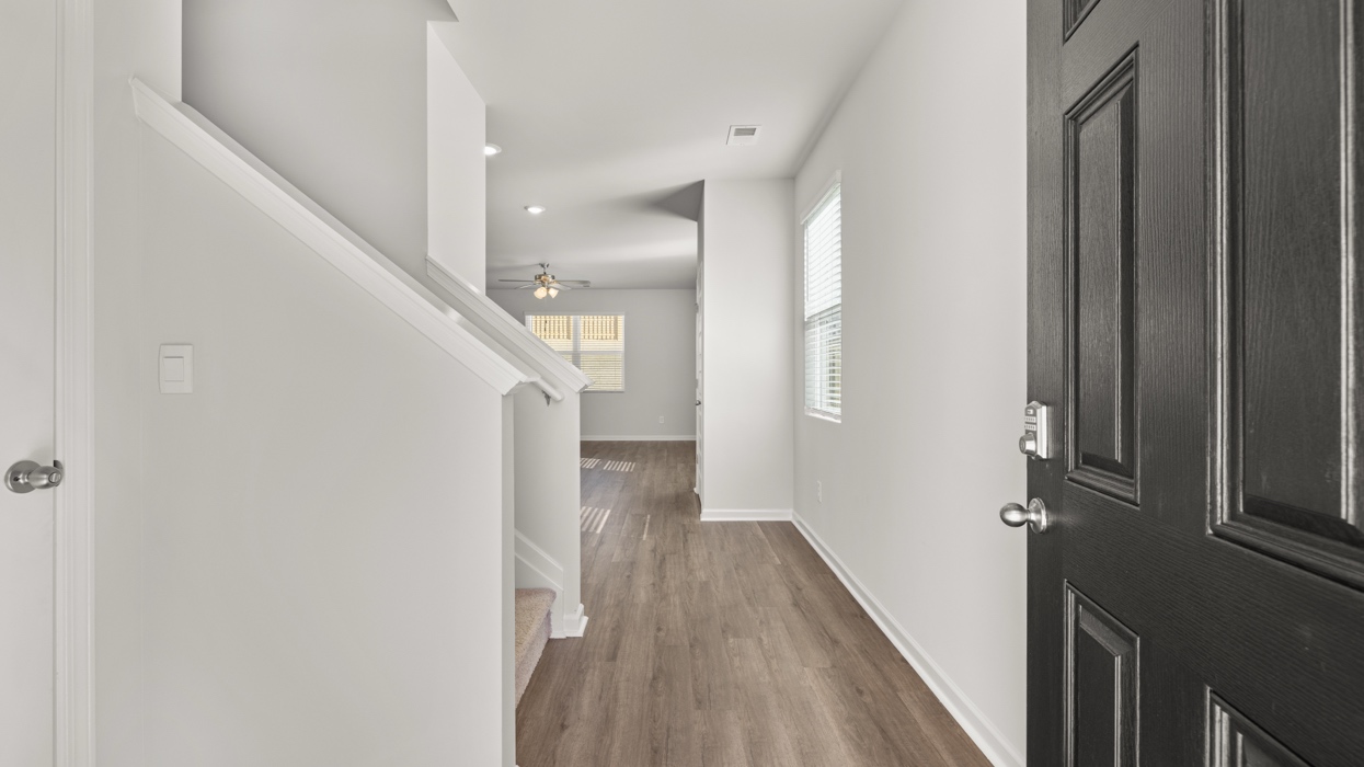 Front door opening to main hallway with staircase along left.