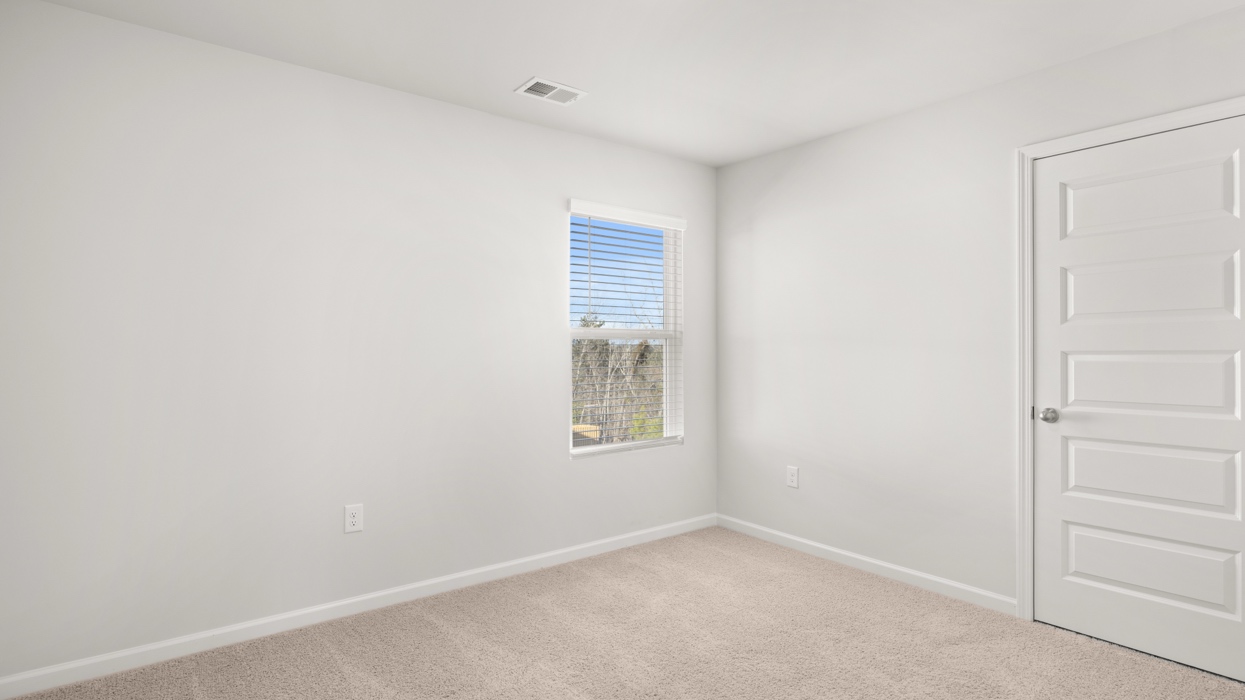 Guest bedroom upstairs with carpeting.