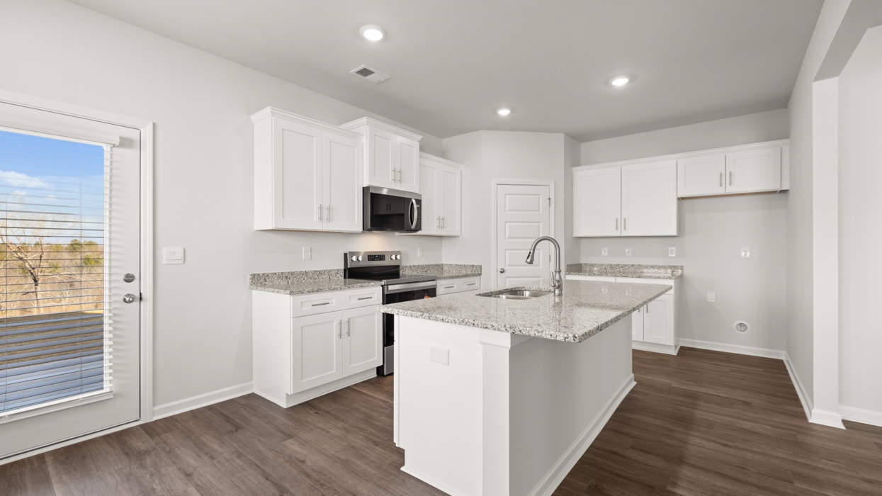 Modern kitchen with shaker cabinets, granite counters, stainless steel appliances, and a large center island with bar seating.
