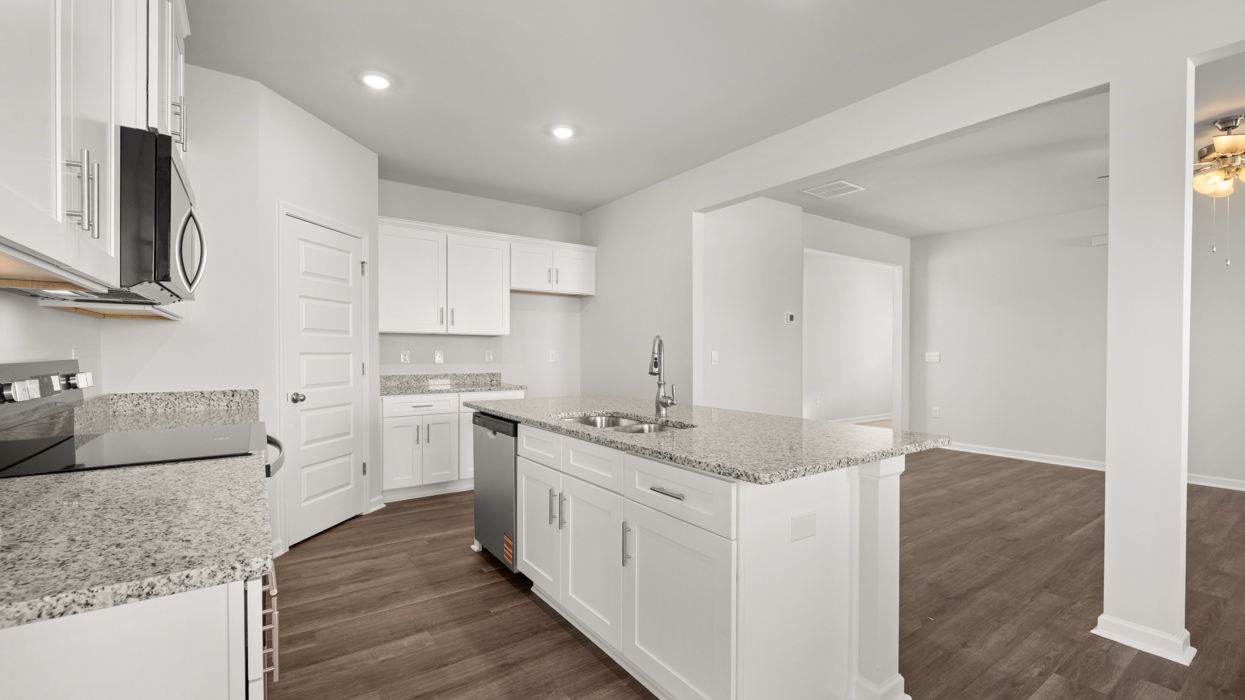 Modern kitchen with shaker cabinets, granite counters, stainless steel appliances, and a large center island with bar seating.