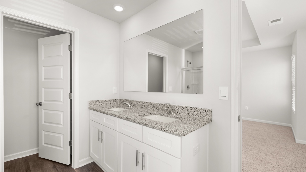 Primary bath with double vanity, garden tub, shower with glass door, and water closet.